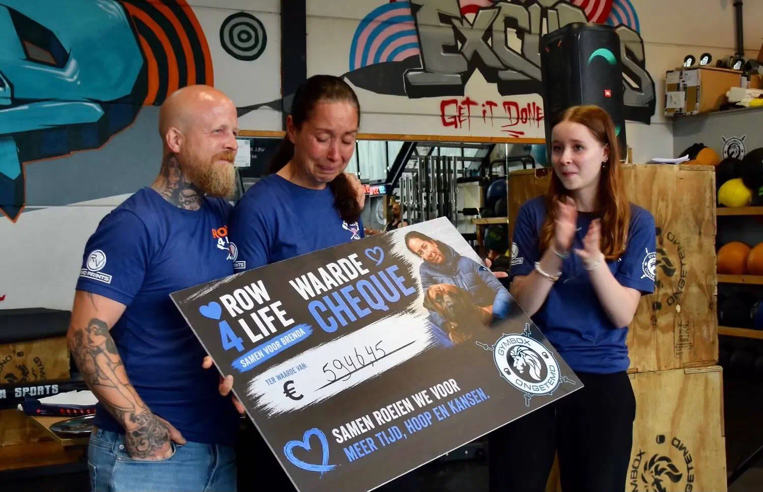Brenda en haar gezin met de cheque van Row 4 Life