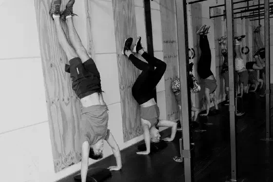 Sporters trainen handstand push-ups tegen de muur